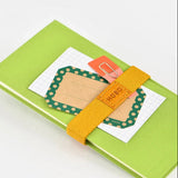 Handy for keeping your book shut in your bag, this bookband is made with an elastic band adorned with the Hobonichi “Hobo” logo. There are two different holes to fit the clasp so you can still use it if your book becomes thicker.

Included in the bookband are slots to store two pens, and the bands come in six colors. (Classic uses natural leather and will grow darker over continued use.)