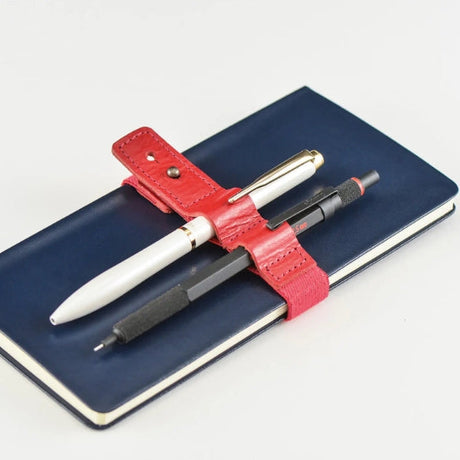 Handy for keeping your book shut in your bag, this bookband is made with an elastic band adorned with the Hobonichi “Hobo” logo. There are two different holes to fit the clasp so you can still use it if your book becomes thicker.

Included in the bookband are slots to store two pens, and the bands come in six colors. (Classic uses natural leather and will grow darker over continued use.)