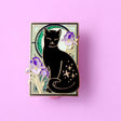 This cute Iris Cat enamel pin features a sweet black cat surrounded by iris (flag) flowers, in front of a glittery moon set against an ornamental green art nouveau background.

The pin is secured by two purple heart backs and comes on a special ‘Art Nouveau’ Glitter Punk backing card, making it perfect for a gift or to keep as a special treat for yourself.

This pin is part of my Art Nouveau Cats collection – 8 enamel pins based on the fabulous 19th/20th century art movement. Check out the full collection a