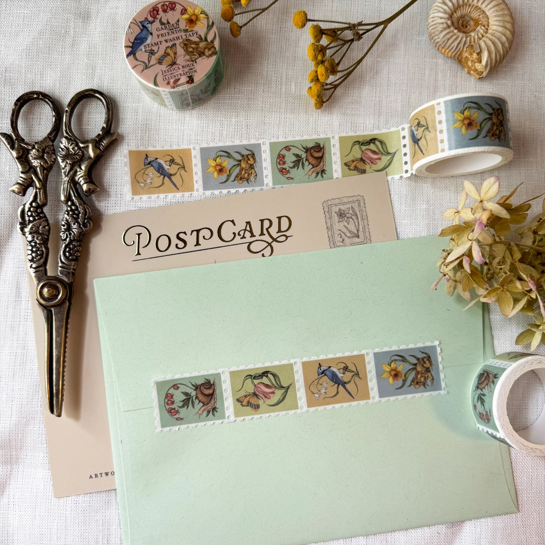 Washi tape featuring garden friends, including a blue jay with a snowflake flower, a toad with a daffodil, a moth and ladybug with a tulip, and a snail with a bleeding heart plant. Illustrated by Jessica Roux.

Each tape is 25mm wide. Individual stamps feature perforation for tearing or cutting. Matte finish perfect for scrapbooking, bullet journaling, and more.

Please note, these are decorative and have no postage value.

Each tape is shrink wrapped and has a sticker label.