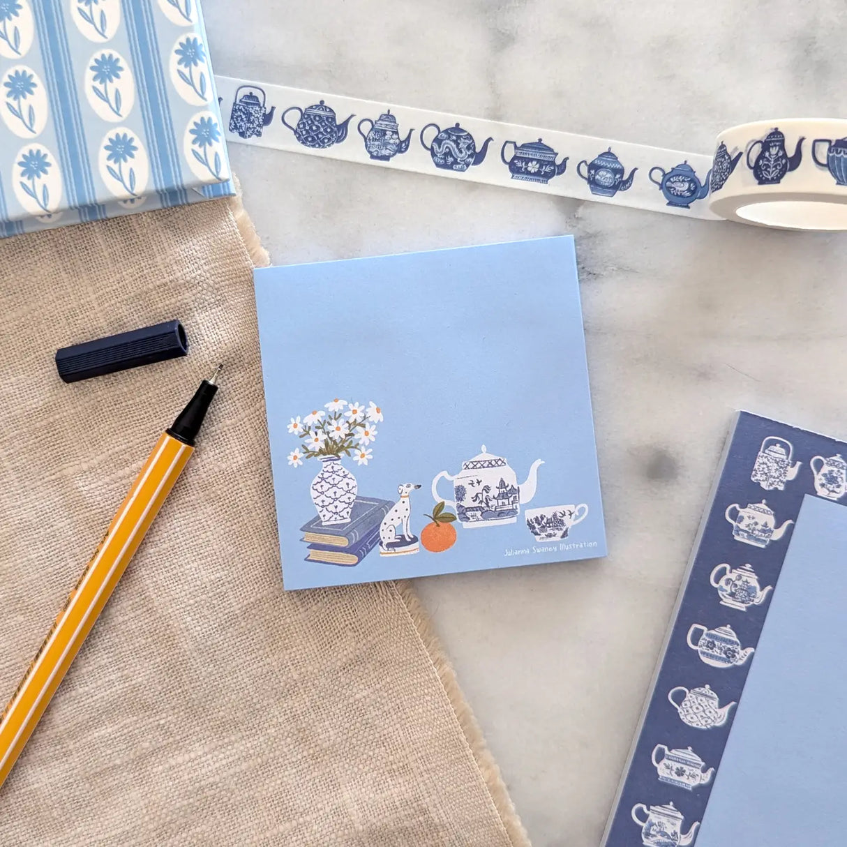 A simple sticky notepad for jotting down to-do's, grocery lists, or whatever you need to remember. Illustrated with a willow pattern tea set, Staffordsire dalmatian figurine, and vase of daisies.