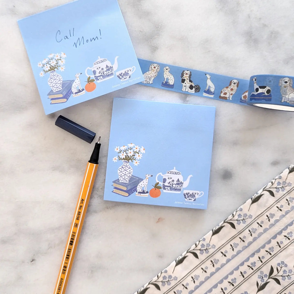 A simple sticky notepad for jotting down to-do's, grocery lists, or whatever you need to remember. Illustrated with a willow pattern tea set, Staffordsire dalmatian figurine, and vase of daisies.