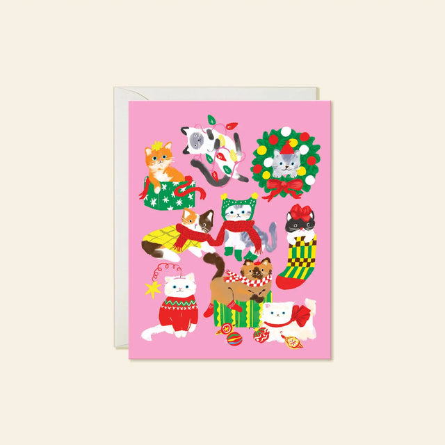 Karen Schipper Greeting Card - Christmas Cats

A pink holiday scene packed with cats in sweaters, scarves, stockings, bows, lights, and gift boxes makes this design feel instantly merry. This hand-illustrated Christmas Cats holiday card brings together playful feline characters and festive details, making it a cheerful pick for cat lovers and those who want a Christmas card with extra personality. 

A2 folded card, 4.25" W × 5.5" L
Printed in full color on FSC® certified white cover paper
Blank interior
Sin