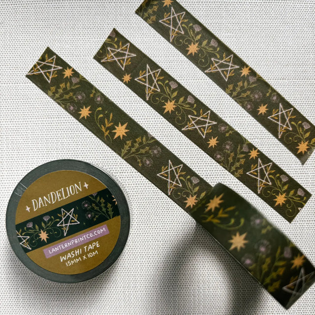 Removable Washi craft tape for journaling and gift wrapping; featuring dandelions and pentagrams on a dark green background.