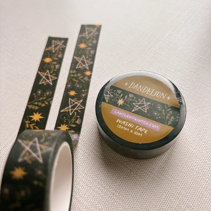 Removable Washi craft tape for journaling and gift wrapping; featuring dandelions and pentagrams on a dark green background.