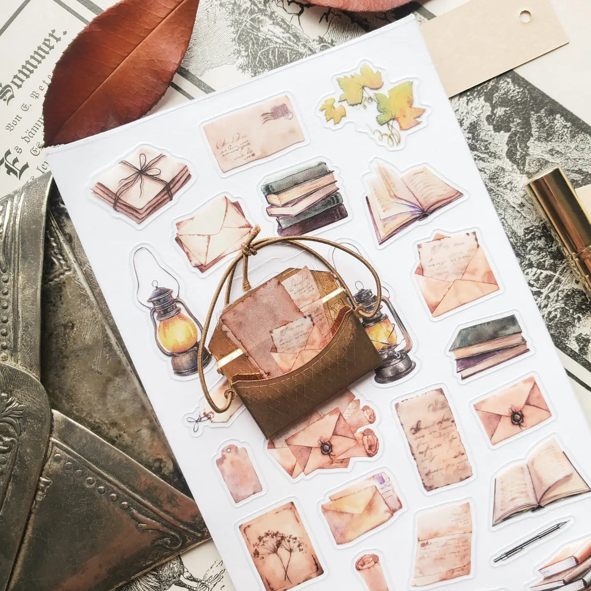 📜🕯️ A stack of letters waits to be opened in @jeannadano’s vintage-inspired stationery set. Weathered envelopes, handwritten notes, and well-loved books, all gathered together as if for a quiet evening of reading and reflection. With delicate paper textures and warm, timeworn tones, this charming set captures the feeling of sunlight on antique paper. Art by: @jeannadano

Top Coating: None
Adhesive Layer: Paper
Backing Layer: Paper
6.69" x 3.54".
Weight - 0.03lbs.
1 sheet included &nbsp; &nbsp;