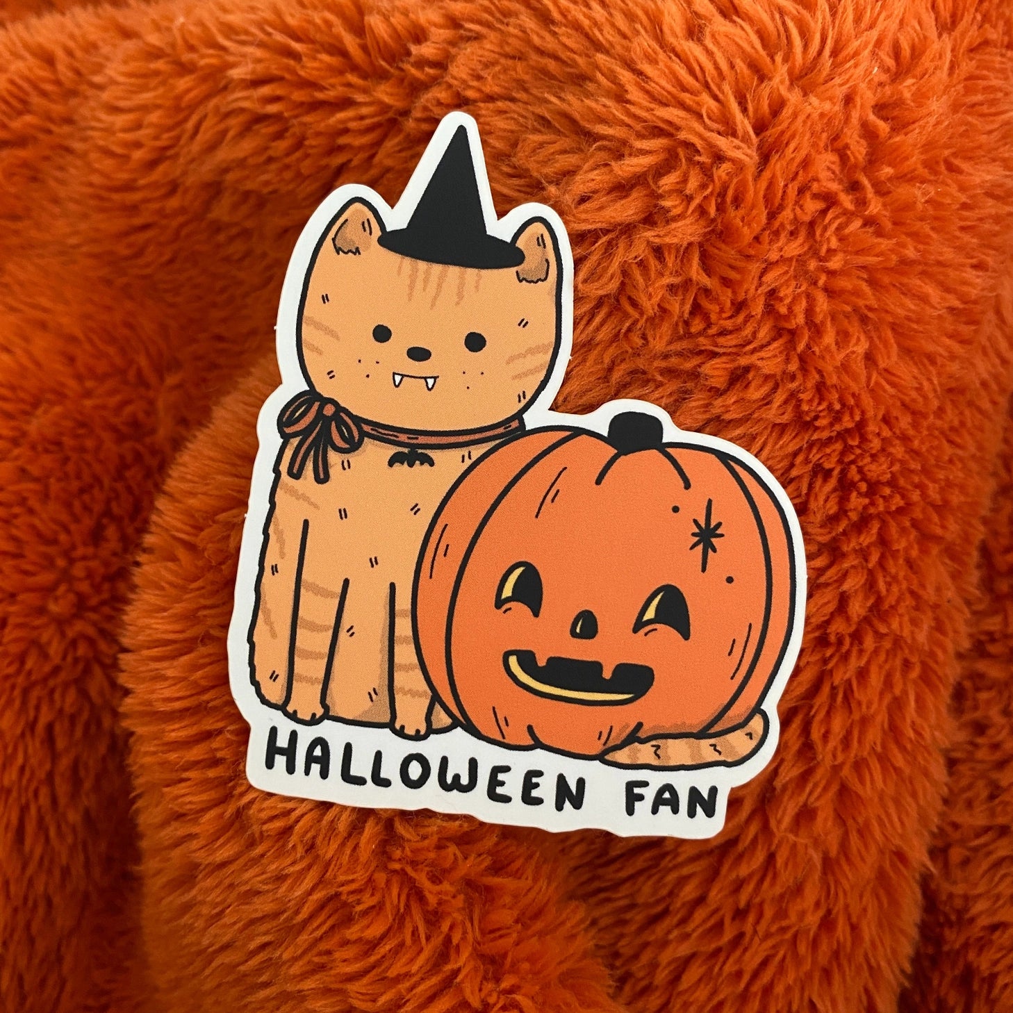 Are you a Halloween fan? This sticker just let’s everyone know! A sticker of a cute little orange cat with a pumpkin.

Waterproof
Matte finish