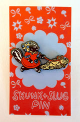 A Skunk and their friend the Slug take a walk through the forest.

This hard enamel pin measures approximately 1.75" and features a rubber clasp for easy closure and two back posts so pin stays where you stick it. Comes with a back card.