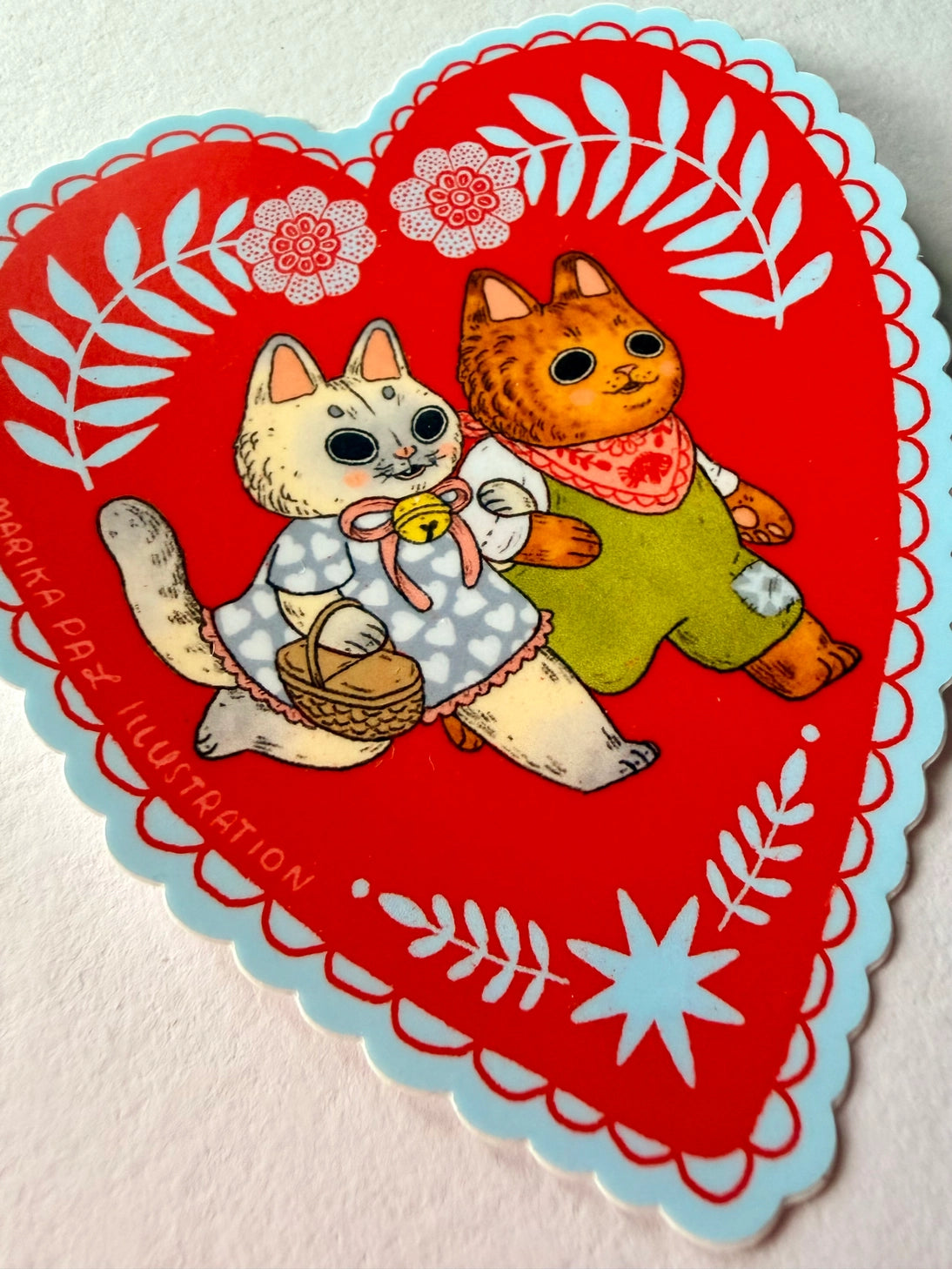 Two cats go for a walk on this folk art inspired sticker.

This vinyl matte sticker is weather and waterproof-stick it on a notebook, bike, or car- it's going to stick around! Heck, throw it on a water bottle and through the dishwasher. This sticker can go anywhere. Sticker measures 3.5" x 4.5" Printed in USA.