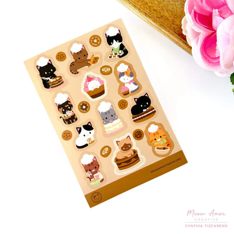 This vinyl sticker sheet features charming cat bakers decorating cakes, frosting cookies, and preparing all sorts of yummy goodies. Brighten up your belongings with these sweet, durable stickers that stick to laptops, water bottles, journals, and more. Perfect for anyone who adores cats and baking.

4x6 Sheet
Vinyl Sticker
Colors might vary just a bit from your screen.