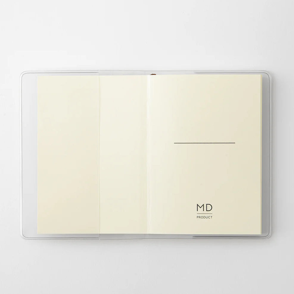 A transparent cover that fits snugly around your MD Notebook

This is a special cover that gently wraps your MD Notebook. The transparent cover protects the notebook from dirt without ruining its appearance.
It subtly protects your notebook from water and dirt without interfering with its characteristics. If you put the cover on with the glassine paper still wrapped around it, the inorganic feel of the vinyl will be softened.
Because it is transparent, you can enjoy the cover design, illustrations, and writ