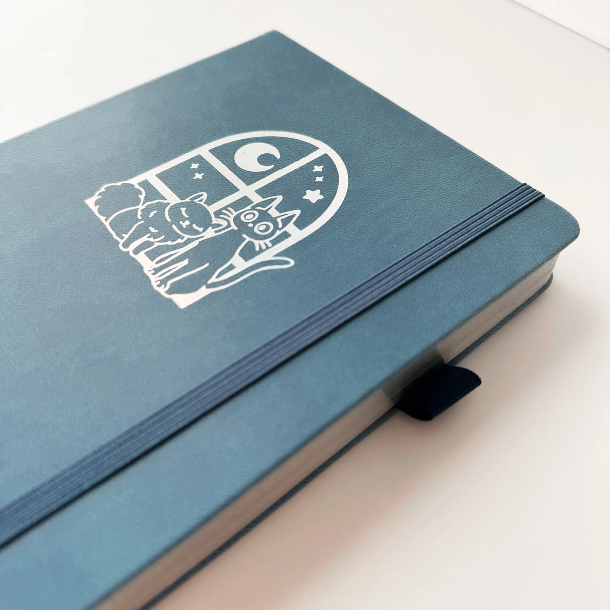 Jiji The Cat Journal in Ocean Blue with Holographic Edges and Logo 🌊✨

Product Details:

Size: A5 (5.70 x 8.26 inches)
160 Dotted Grid Pages (5 x 5 mm)
2 Bookmarks
Elastic Band and Pen Holder
Expandable storage compartment