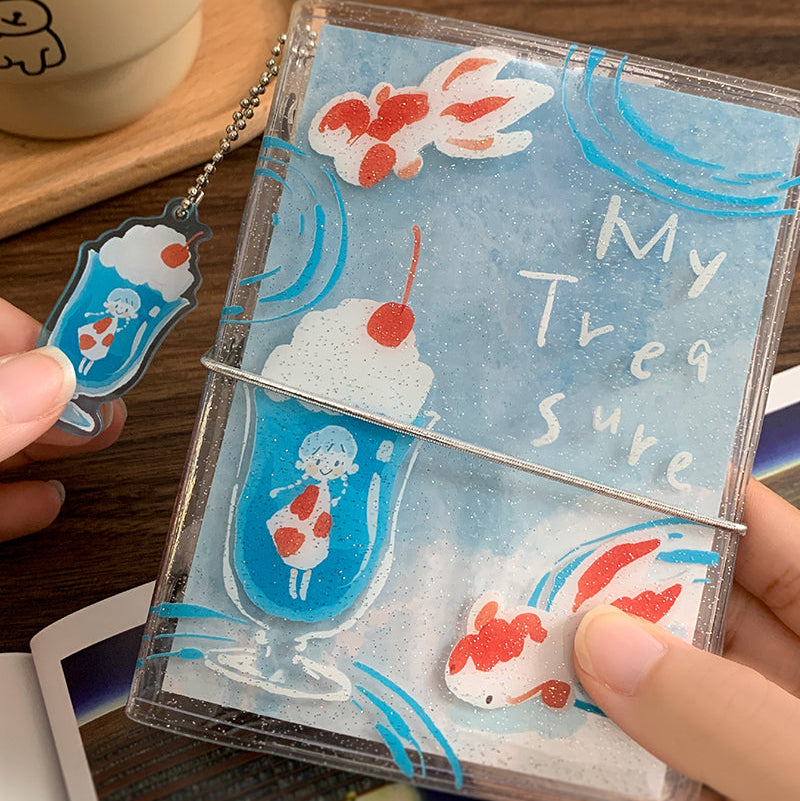 Molinta&nbsp;Binder - Goldfish Soda

Designed in a compact six‑ring format, this binder is perfect for organizing ephemera, sticker sheets, journaling inserts, and creative plans. Lightweight and easy to carry, this binder slips effortlessly into bags, totes, or your desk setup.

Specifications:

M5: 95mm x 128mm, 5 rings
A7: 102mm x 153mm, 6 rings

Includes soda keychain and elastic closure band.

Inserts not included