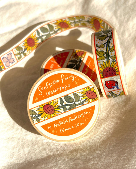 This washi tape features little sunflowers dancing one by one separated by flowers and strawberries. This tape design is taken from my Sunflower Fairy print's decorative borders.

This roll is 15mm wide x 10m of paper tape. Washi tape is super durable and flexible. It tears easily and can be safely applied to a variety of surfaces; it doesn’t leave a sticky residue behind, making it especially ideal for stationery and hanging prints temporarily.