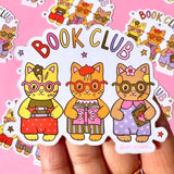 These adorable book themed stickers are perfect for sharing with your book club friends. It features 3 adorable cats with their favorite reads!

These matte vinyl stickers feature an original design and are water, weather, and scratch proof. Perfect for putting on water bottles, computers or just about anywhere else.