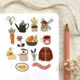 A matte paper sticker sheet filled with cozy, hand-drawn illustrations, perfect for planners, journals, or scrapbooking. It features a cozy spring and hygge season theme, making it a perfect fit for mindful living enthusiasts. All designs are lovingly created by Monika Szczerbińska.