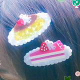 Pudding & Cake Hair Clips as a set of two clips. Clips are 2.5 inches long, made of acetate and have an alligator style clip on the back.

Clips should not be submerged in water.

Hair clips come with a backing card in a plastic sleeve.