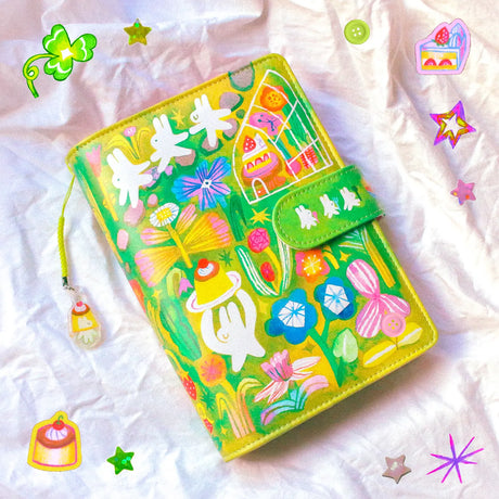 This is a A6 six ring binder that measures 14 cm x 19 cm when closed! It includes interior pockets for extra storage and a hole on the spine for charms.

This binder is great for storing stickers, sticker packs, note cards, photo cards, pet tape loops, ephemera and small sticker sheets. They can also be filled with paper and used as a notebook or journal.