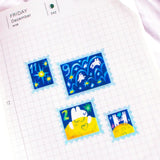'To the Moon &amp; Back' Frosted Glitter Transparent A6 Sticker Sheet. Stickers are stamp shaped and have a clear blue background.

Not waterproof.
Do not place in areas of high wear (laptops, phone cases, water bottles, etc).
Sticker sheets come packaged in a plastic sleeve.