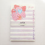 Inside a cozy Wildflower Woods cottage, a curious cat lounges among broad monstera leaves, tucked into a corner filled with filtered light and trailing greenery. This notepad brings that leafy, lived-in moment to your desk, making everyday lists feel a little more inviting.

Designed to be practical without feeling busy, this notepad offers a simple, cheerful way to keep track of daily to-do lists and planning.