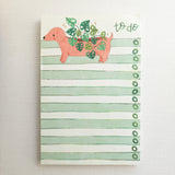 In a sunny Wildflower Woods cottage, a dachshund planter rests near a stack of well-loved books, leafy greens spilling gently from its back. This notepad brings that cozy, decorative moment to your desk, making everyday lists feel a little more inviting.

Designed to be practical without feeling busy, this notepad offers a simple, cheerful way to keep track of daily to-do lists and planning.