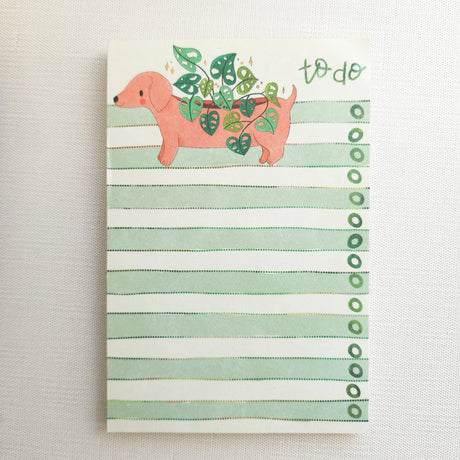 In a sunny Wildflower Woods cottage, a dachshund planter rests near a stack of well-loved books, leafy greens spilling gently from its back. This notepad brings that cozy, decorative moment to your desk, making everyday lists feel a little more inviting.

Designed to be practical without feeling busy, this notepad offers a simple, cheerful way to keep track of daily to-do lists and planning.