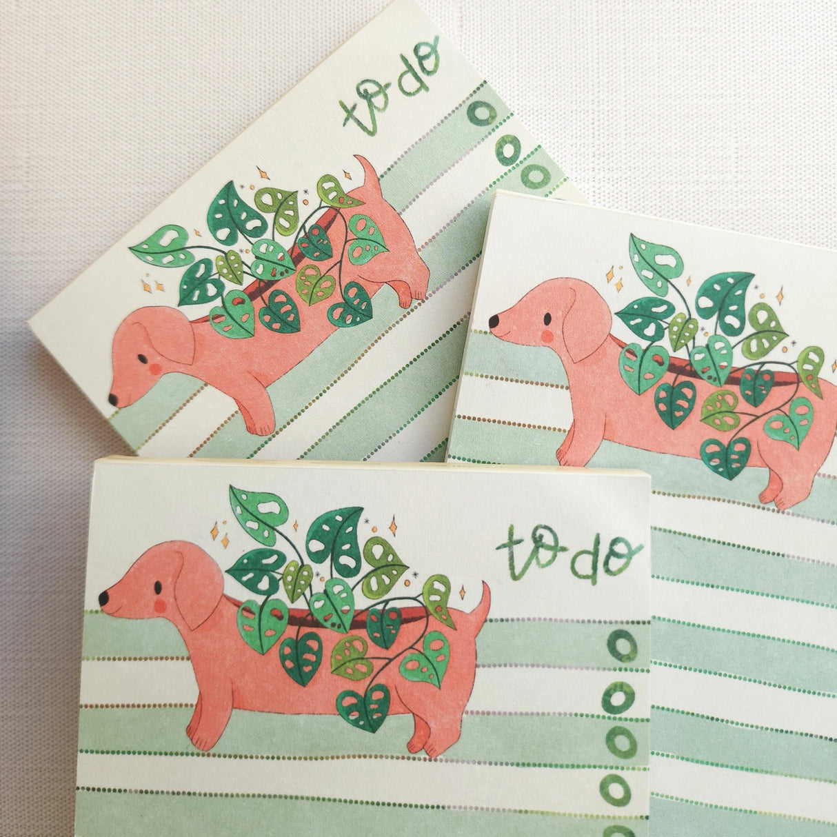 In a sunny Wildflower Woods cottage, a dachshund planter rests near a stack of well-loved books, leafy greens spilling gently from its back. This notepad brings that cozy, decorative moment to your desk, making everyday lists feel a little more inviting.

Designed to be practical without feeling busy, this notepad offers a simple, cheerful way to keep track of daily to-do lists and planning.
