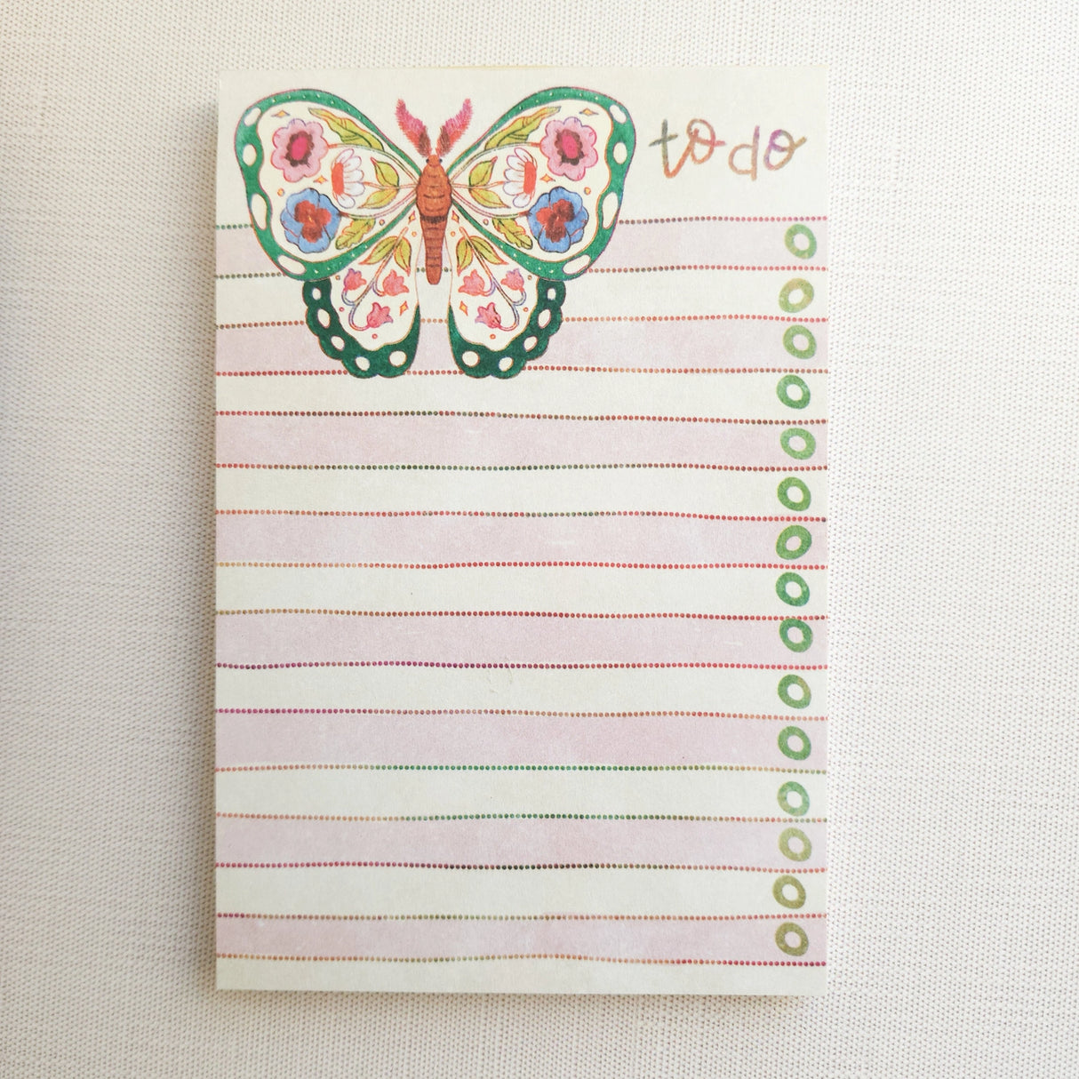 In the gardens of Wildflower Woods, a butterfly drifts from bloom to bloom, wings patterned with flowers gathered along the way. This notepad brings that light, floral moment to your desk, making everyday lists feel a little more inviting.

Designed to be practical without feeling busy, this notepad offers a simple, cheerful way to keep track of daily to-do lists and planning.