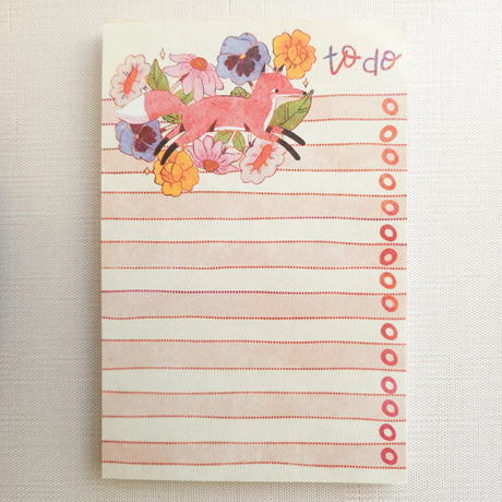 In a quiet clearing of Wildflower Woods, a fox moves through blooming flowers, petals lifting gently as he passes beneath open sky. This notepad brings that playful, woodland moment to your desk, making everyday lists feel a little more inviting.

Designed to be practical without feeling busy, this notepad offers a simple, cheerful way to keep track of daily to-do lists and planning.