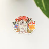 A charming dachshund planter rests among leafy greenery, a thriving cheese plant growing from its back like a small piece of playful décor. This vinyl sticker captures that cozy, plant-filled still life, adding a touch of warmth and whimsy to your everyday essentials.

Made from durable, waterproof vinyl, this sticker is designed to hold up wherever you place it—whether that’s a water bottle, laptop, or journal you reach for daily.