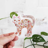 A calm cat returns from the blooming meadows of Wildflower Woods, patterned with flowers gathered along the way. This vinyl sticker captures that quiet, reflective moment, carrying a simple reminder to let yourself bloom.

Made from durable, waterproof vinyl, this sticker is designed to hold up wherever you place it—whether that’s a water bottle, laptop, or journal you reach for daily.