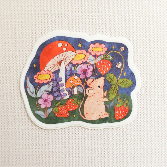 A cheerful little mouse pauses along a sunny garden path in Wildflower Woods, holding a ripe strawberry close before continuing on its way. This vinyl sticker captures that small, joyful moment, celebrating the simple pleasures tucked into everyday life.

Made from durable, waterproof vinyl, this sticker is designed to hold up wherever you place it—whether that’s a water bottle, laptop, or journal you reach for daily.