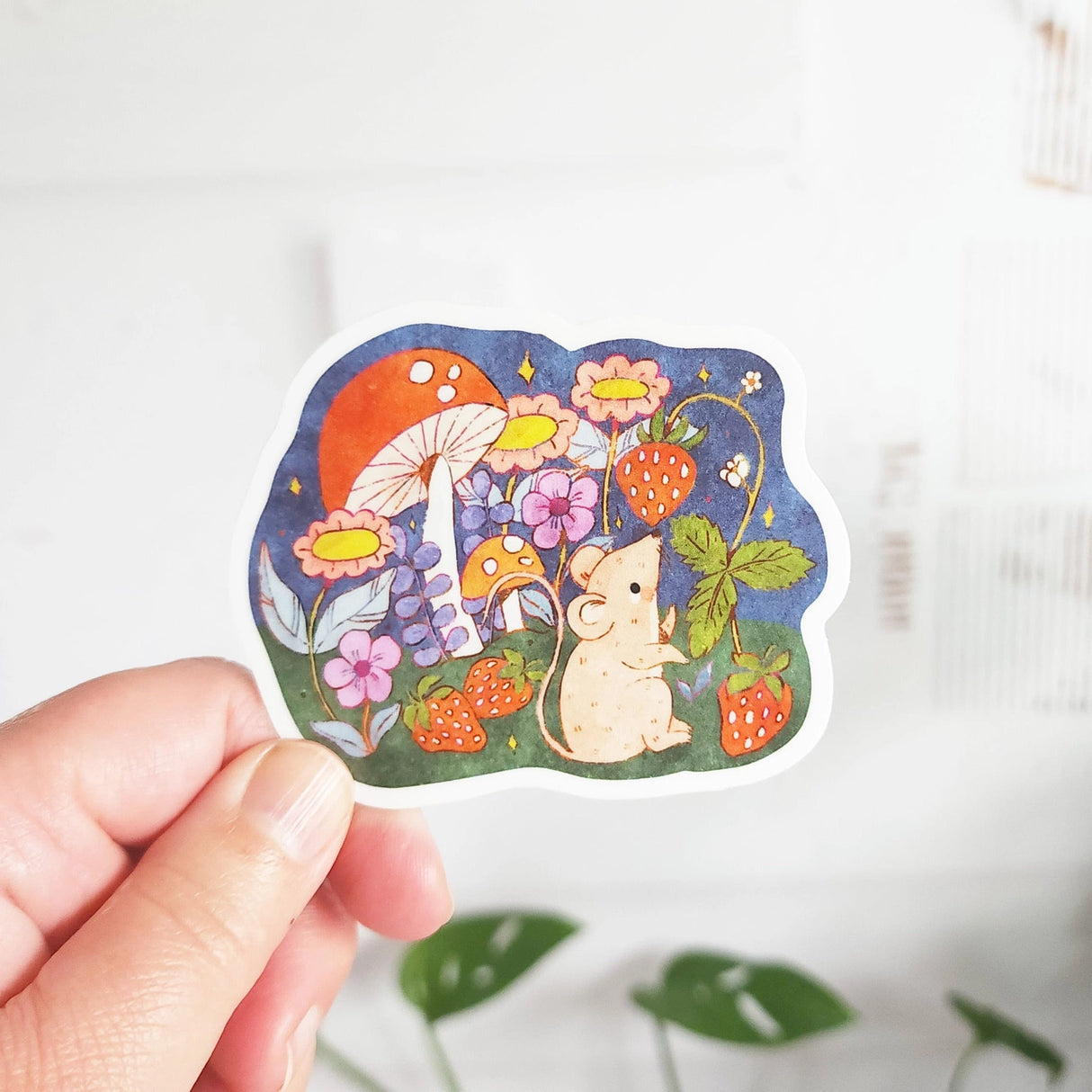 A cheerful little mouse pauses along a sunny garden path in Wildflower Woods, holding a ripe strawberry close before continuing on its way. This vinyl sticker captures that small, joyful moment, celebrating the simple pleasures tucked into everyday life.

Made from durable, waterproof vinyl, this sticker is designed to hold up wherever you place it—whether that’s a water bottle, laptop, or journal you reach for daily.