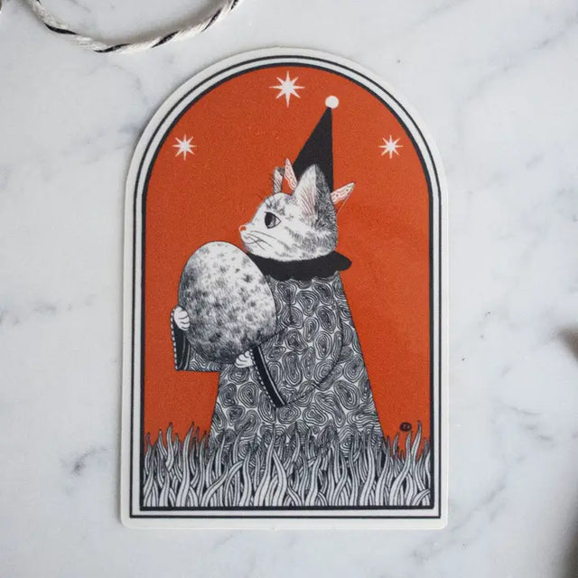 Unleash the magic with our Wizard Vinyl Sticker. This enchanting sticker features a mystical feline wizard, carefully holding a mysterious egg, poised for the moment of transformation. Apply this sticker to any surface, from your laptop to your notebook, and watch the enchantment unfold. Its white background complements any backdrop. Crafted from durable white glossy vinyl, this sticker will remain vivid and intact for a long time.