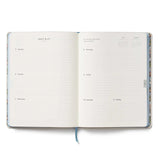 A daily essential with keepsake quality. With a cover inspired by classic cross stitch samplers, this fabric-wrapped planner features gold foil details, weekly and monthly views, space for notes and to-dos, and a list of celebrations.&nbsp;

DETAILS

Printed in full color with foil stamped year
Book cloth cover with ivory uncoated paper
Natural white text paper interior
January 2027-December 2027
Monthly and weekly views
Space for notes each week
List of celebrations
7.18" W x 9.62" L