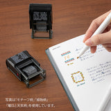 This fun rotating stamp by Midori allows you to choose from several designs and patterns that come with each stamp. The rotating stamp comes with an ink pad to be installed into the stamp before beginning to use it. Lock buttons on the side of the stamp allow you to lock the stamp into place when changing out the ink pad and when changing between designs to avoid mess.