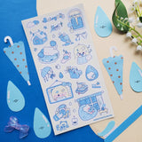 ☔💙 Cozy up and let the rain fall with this soothing blue-toned sheet! Filled with sleepy cats, soft blue umbrellas, rainy windows, warm drinks, and quiet little indoor moments, it captures all the best parts of a slow rainy day. Perfect for anyone who loves the peaceful magic of staying in, getting comfy, and listening to the gentle sound of raindrops outside.