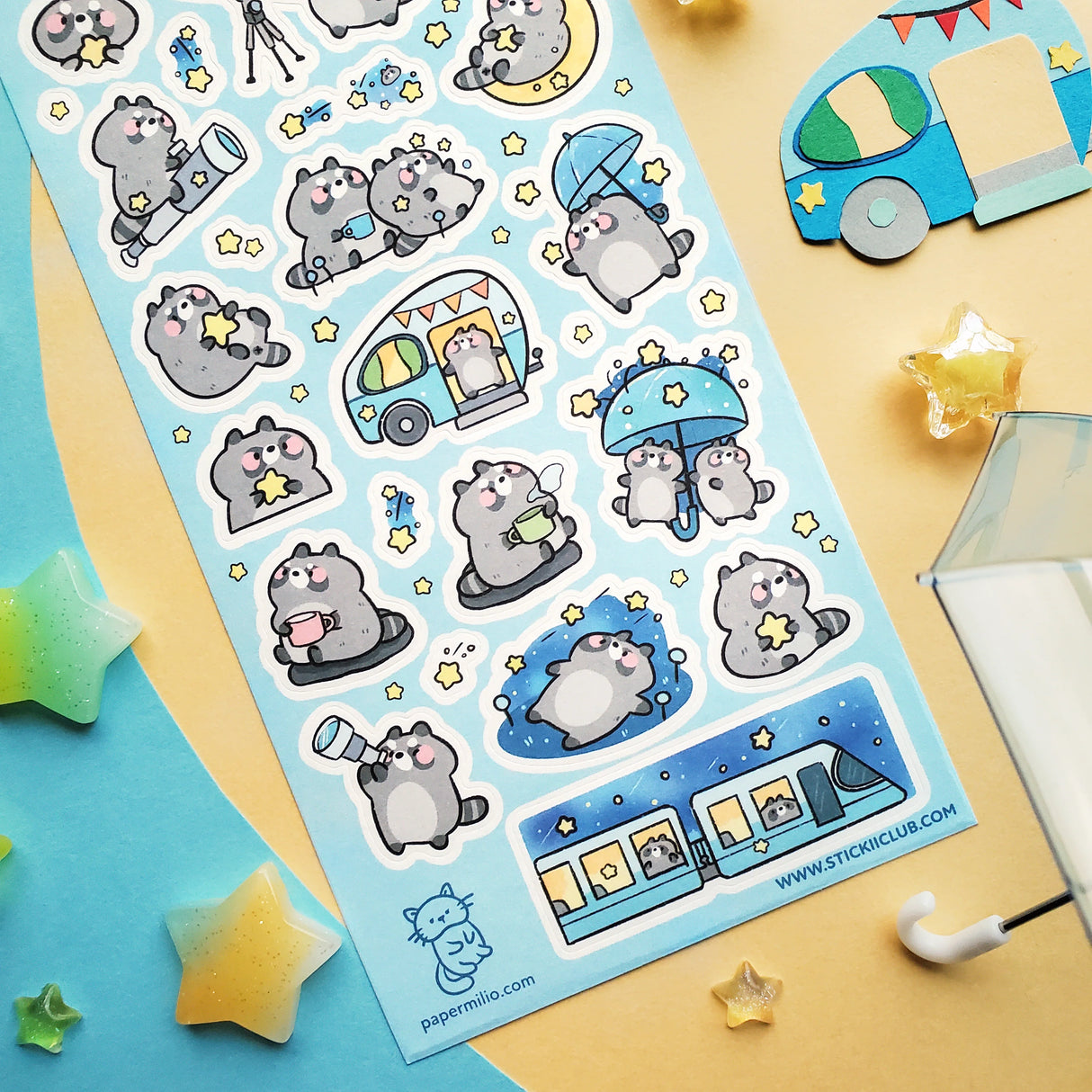 🌟🦝 Adventure calls, and these chonky little stargazers by @papermilio are answering, with snacks packed and eyes on the sky! From peeking through telescopes and wishing on shooting stars to camper trips, and umbrella strolls beneath twinkly skies, these cosmic cuties are following the stars—wherever they may lead.