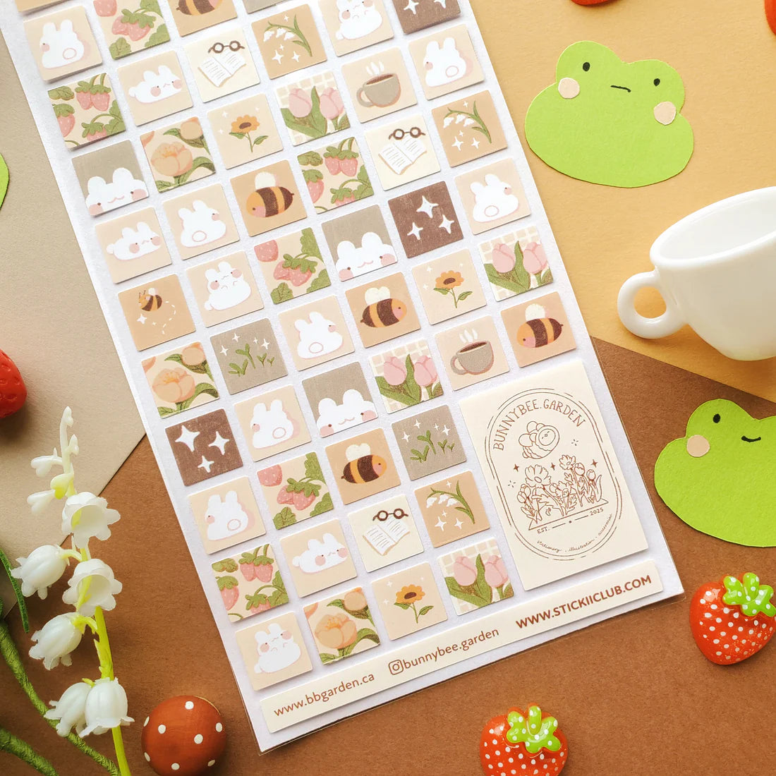 🌻🐝 Buzz on over to @bunnybee.garden’s whimsical garden, where chubby bunny-bees flutter through fields of flowers and cozy mushroom hideaways. From watering plants and zooming past blooming petals to splashing in puddles and snoozing in grassy corners, this sheet is bee-yond adorable.


Art by: @bunnybee.garden

Top Coating: None
Adhesive Layer: Paper
Backing Layer: Clear PET
6.69" x 3.54".
Weight - 0.03lbs.
1 sheet included