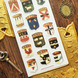 Step into the grand halls of ancient kingdoms with this striking collection of heraldic crests. From star-studded banners and geometric sigils to proud animal emblems symbolizing strength, loyalty, and courage, each shield carries the spirit of medieval artistry and old-world craftsmanship.

Top Coating: None
Adhesive Layer: Paper&nbsp;
Backing Layer: Clear PET
Size: 6.69" x 3.54"
1 sheet included