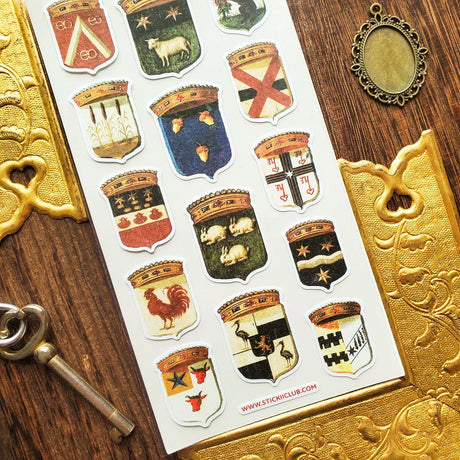 Step into the grand halls of ancient kingdoms with this striking collection of heraldic crests. From star-studded banners and geometric sigils to proud animal emblems symbolizing strength, loyalty, and courage, each shield carries the spirit of medieval artistry and old-world craftsmanship.

Top Coating: None
Adhesive Layer: Paper&nbsp;
Backing Layer: Clear PET
Size: 6.69" x 3.54"
1 sheet included