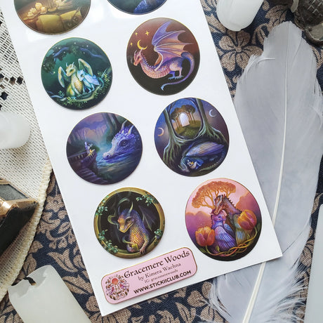🌙🐲 Bathed in moonlight, @gracemerewoods’ dragons stand watch as gentle guardians of ancient forests, glowing gateways, and sacred firelight. Each scene reveals their role as protectors of balance, beauty, and magic. With dreamy brushwork, luminous atmosphere, and timeless fantasy charm, this sheet brings the legend of these mystical keepers to life.

&nbsp;Art by: @gracemerewoods

Top Coating: Gold Foil
Adhesive Layer: Paper
Backing Layer: Clear PET
6.69" x 3.54".
Weight - 0.03lbs.
1 sheet included