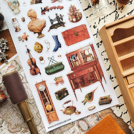STICKII - Treasured Antiques Sticker Sheet

🕰️🧳 Brimming with timeworn treasures, this sheet feels like a quiet afternoon spent wandering through an antique shop. From ornate clocks and old sewing machines to travel trunks, violins, gramophones, and carefully kept curios, each piece captures the charm of objects with a story to tell. Perfect for adding a little old-world elegance, mystery, and nostalgia to your pages.

Top Coating: None
Adhesive Layer: Paper
Backing Layer: Paper
6.69" x 3.54".
Weight - 0.