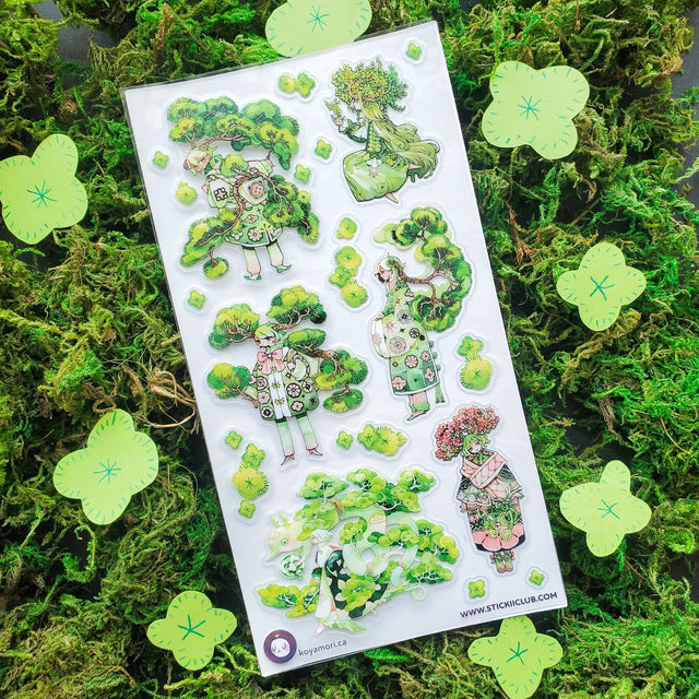 🌳🍃 Get ready to branch out with @maruti_bitamin’s bonsai beauties and leafy legends! These stylish forest guardians rock living tree crowns, flowing robes, and nature magic like it’s the hottest green trend of the season. Rooted in charm and bursting with botanical flair, this set is ready to sprout some serious wow on your pages!

Art by: @maruti_bitamin

Top Coating: None
Adhesive Layer: PVC (plastic)
Backing Layer: Clear PET
6.69" x 3.54".
Weight - 0.03lbs.
1 sheet included &nbsp; &nbsp;