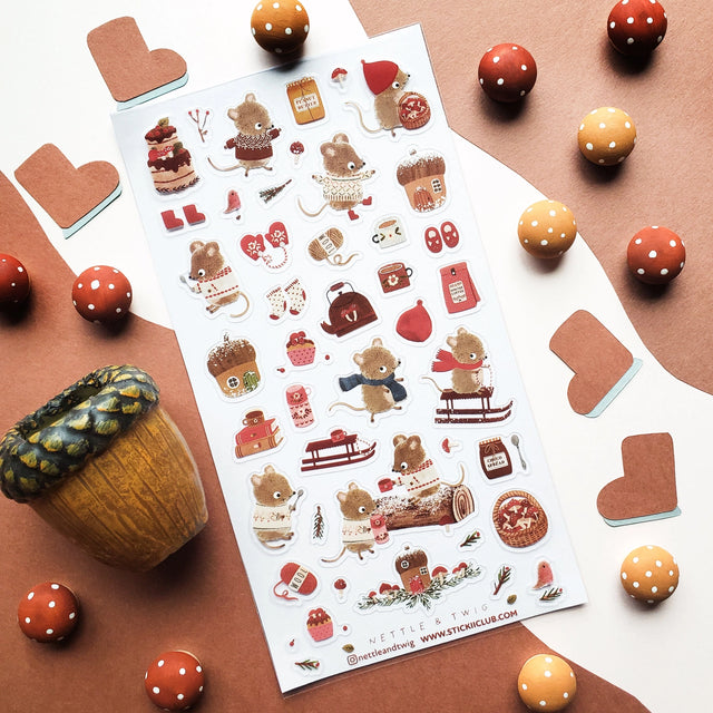 🐭☕️ Cozy up with @nettleandtwig’s snug little mouse village, where winter days are filled with woolly sweaters, steaming cocoa, and muffins fresh from the oven! Among snow-dusted acorn cottages, these tiny friends spend their time sledding, knitting, and sharing warm moments by the fire.

Top Coating: None
Adhesive Layer: PVC (plastic)
Backing Layer: Clear PET
6.69" x 3.54".
Weight - 0.03lbs.
1 sheet included&nbsp;