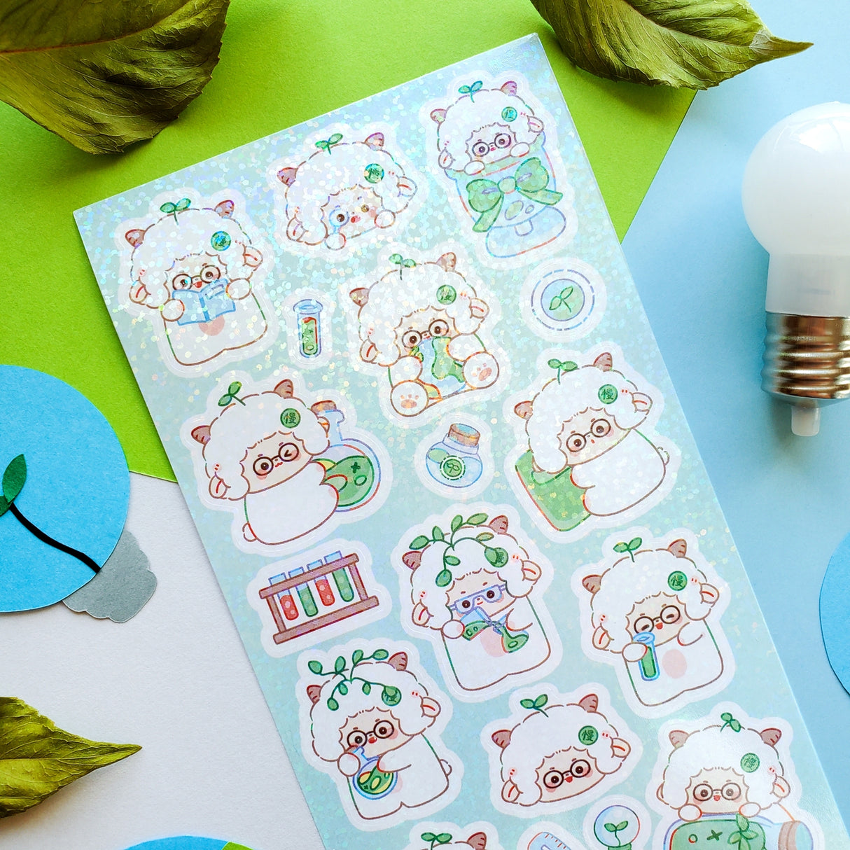 STICKII Science Sheep Sticker Sheet Sheet of cute animal-themed stickers on a colorful background with leaves and a light bulb.