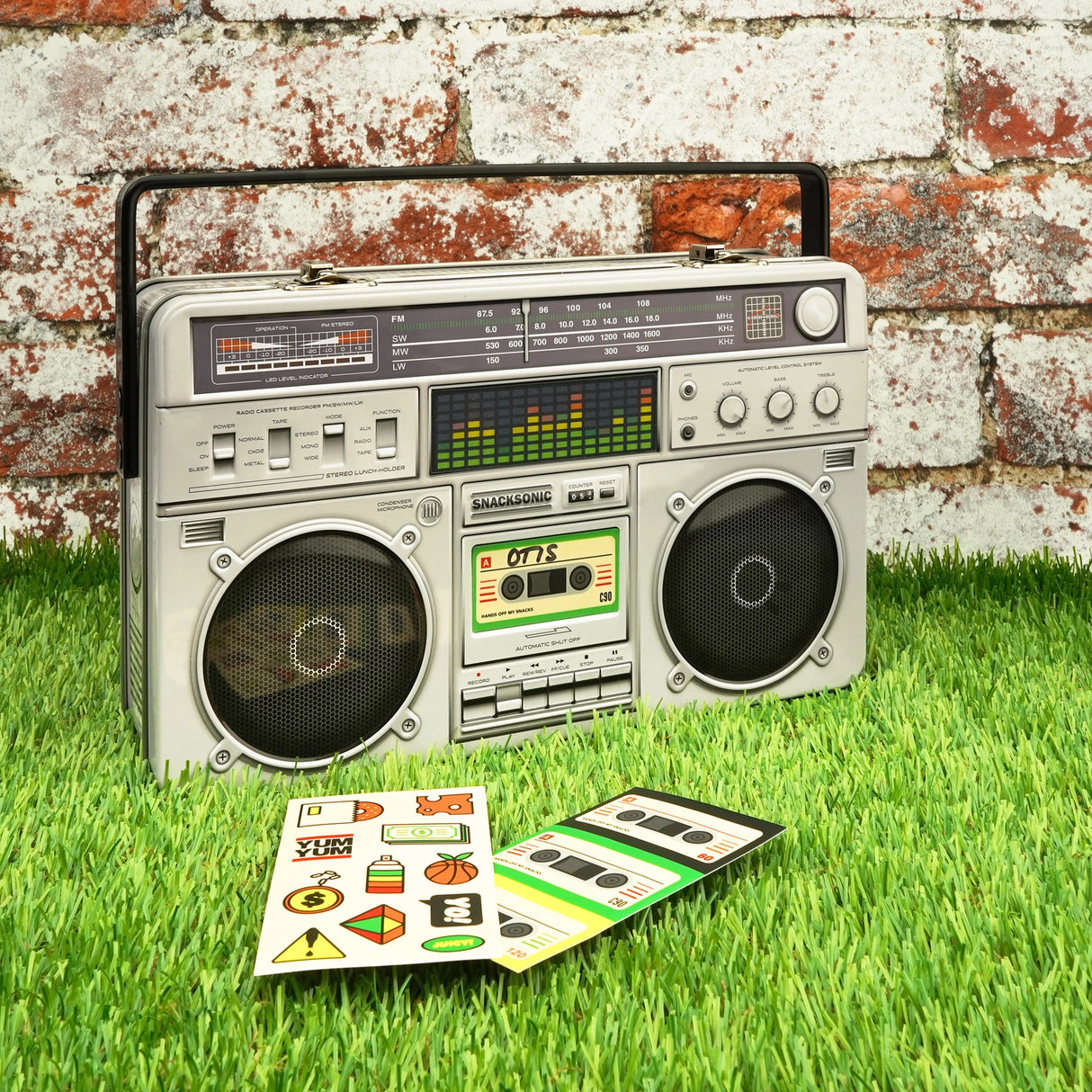 Cool kids bring their own lunch. The coolest kids carry lunch like it's 1989 and you're a street-wise New-York Hip-Hop kid. A classic tin lunch box disguised as a super cool retro ghetto blaster. Big enough for a good size packed lunch and fun enough for both kids and adults. Experience the nostalgia of the 80s. Keep your food fresh and organized. This is not just a lunch box, this is a statement of intent!&nbsp;

Durable and built to last the rigours of school.
Animated lenticular graphic equalizer.
Metal 