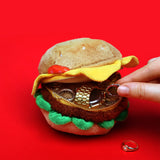 SUCK UK Plush Pouch - Hamburger

Plush burger shaped case with gold zip. Store your belongings amongst the salad and the melted cheese. Yum!

Juicy, tasty, sweet and sour. And very cute. Stuff your stuff into something soft, and squishy. Delicious looking plush zip pouches look like foodie treats but instead of calories, they hold your everyday essentials. From cheesy slices to sickly treats, each pouch is designed to be irresistible and practical. Perfect for pens, cables, cosmetics, or whatever bits and b