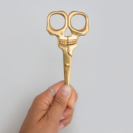 SUCK UK Skull Scissors

Shockingly sharp stainless-steel scissors with a brass finish. From hair-raising haircuts to creepy paper crafts, these heavy-duty general use scissors are both handy and haunting in equal measure. For all eerie everyday tasks, these handy and haunting scissors are tough yet precise. Truly multipurpose, use them to trim your plants, snip your needlework, or even groom your facial hair. Durable stainless steel blades and full metal construction allows them to cut through fabric, paper