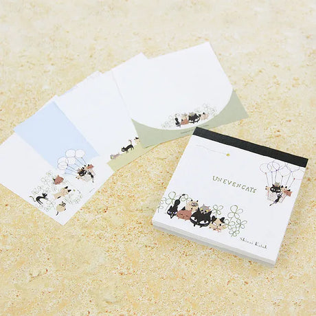 Shinzi Katoh Memo Pad - Uneven Cats Clover Notebook with cat illustrations on a textured surface